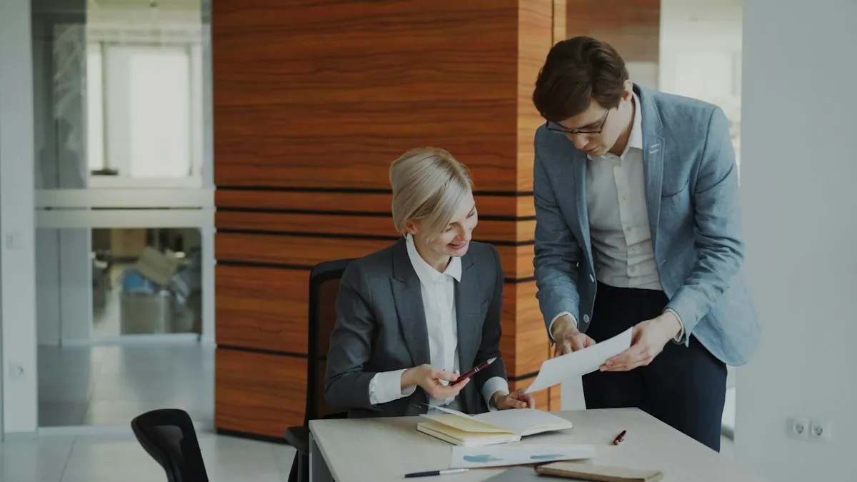Two colleagues reviewing documents at an office desk