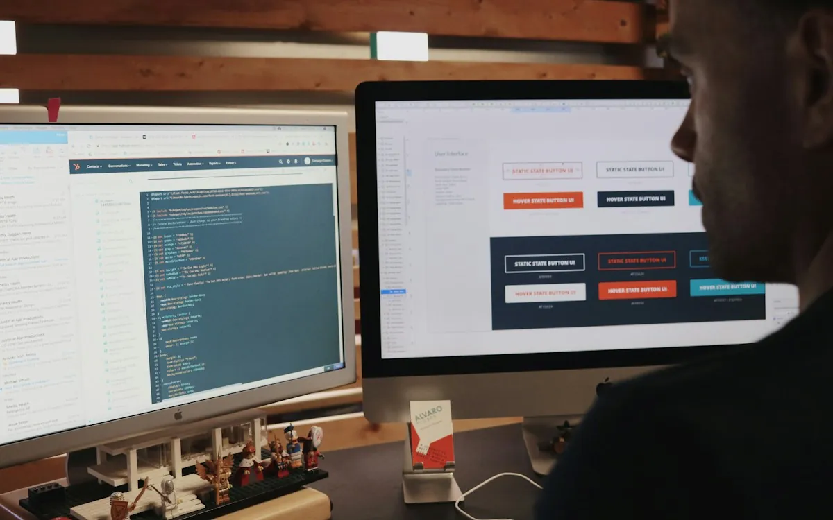 Developer building course screens in an authoring tool on two monitors