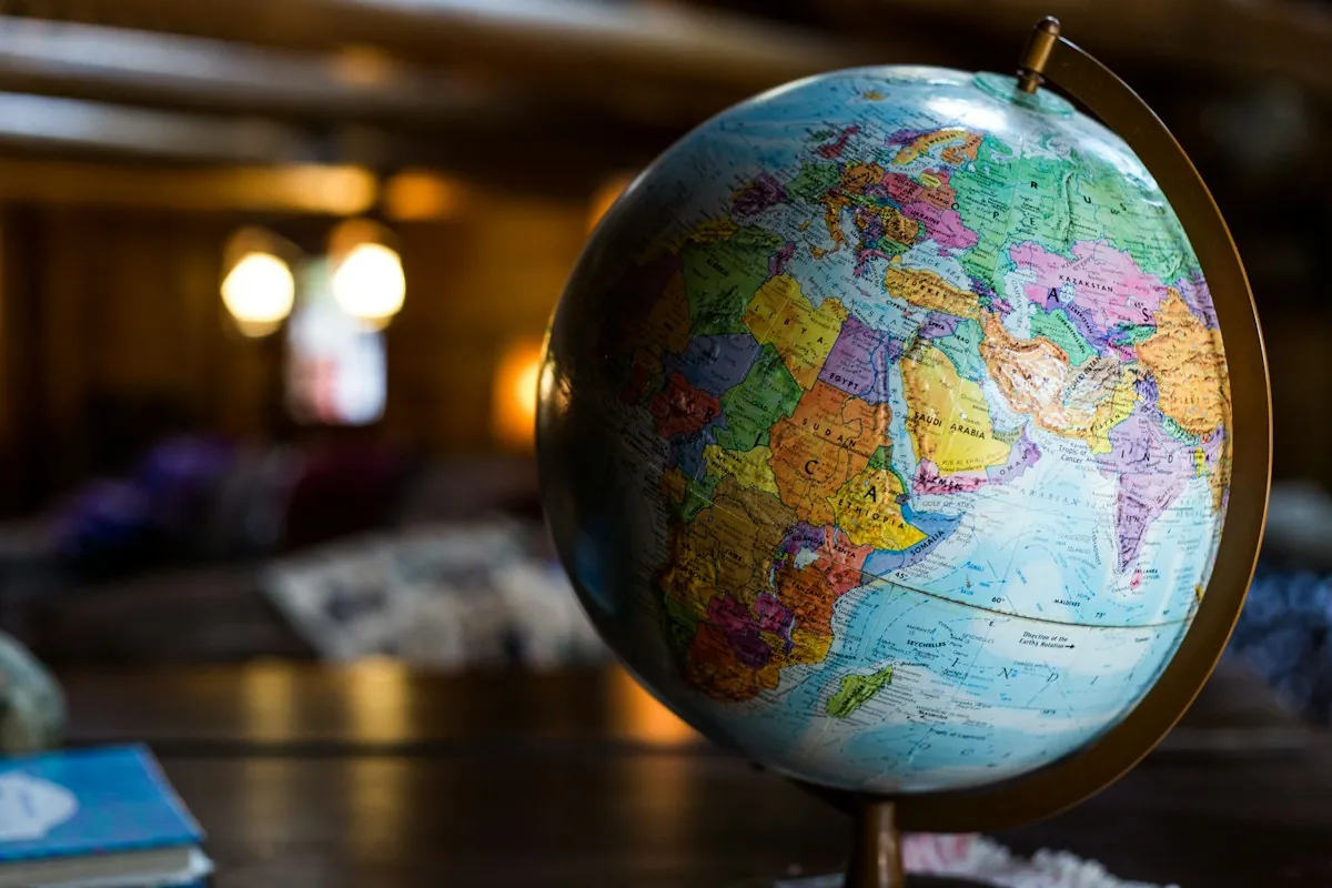 A desk globe on a wooden table in a warmly lit room