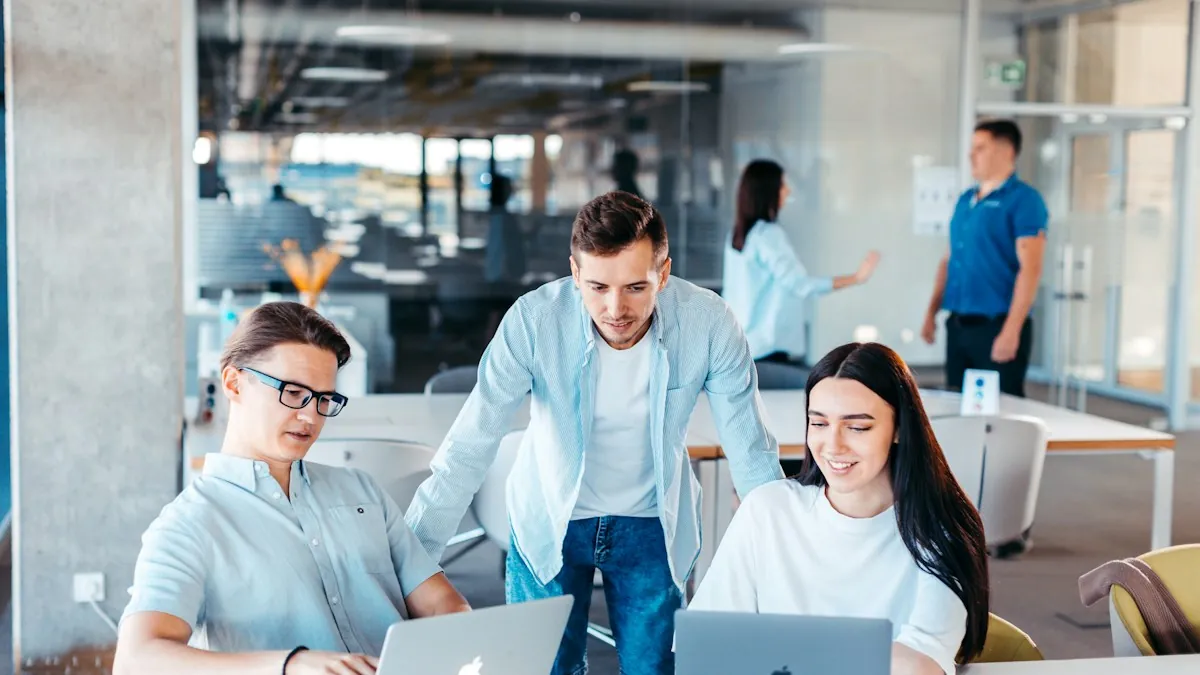 Young sales team working together at laptops in an open-plan office